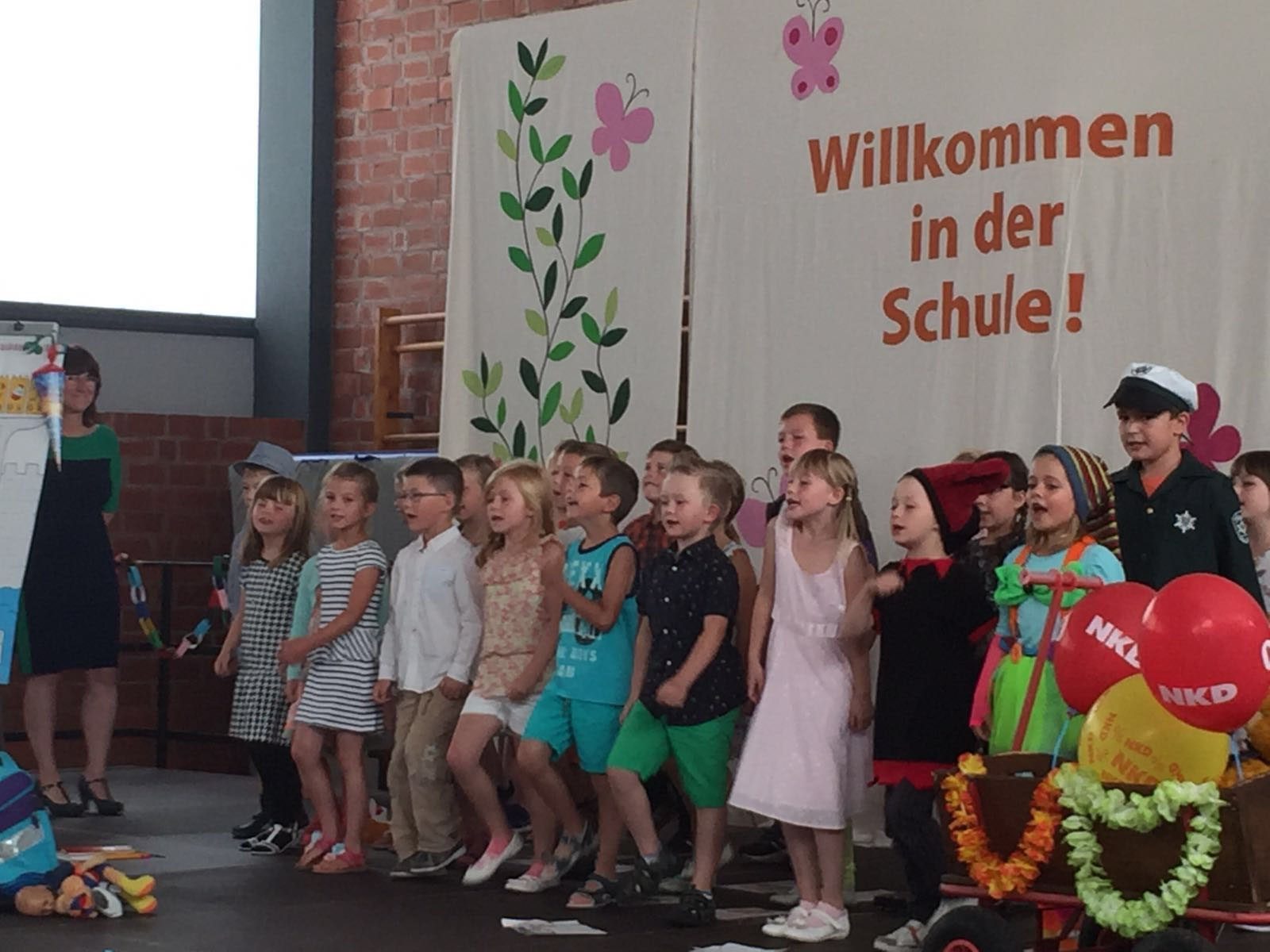 Erstklässler bei der Einschulung vor dem Banner „Willkommen in der Schule“