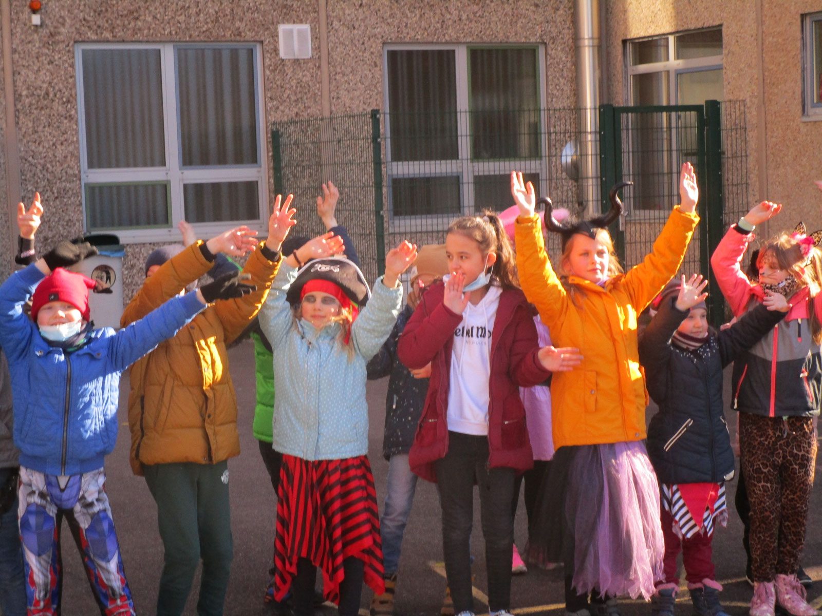 Verkleidete Kinder jubeln auf dem Schulhof