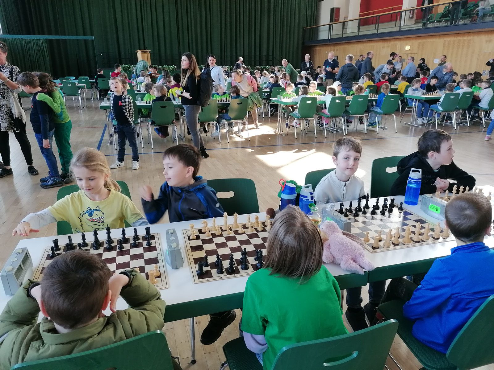 Kinder spielen Schach in einer großen Halle