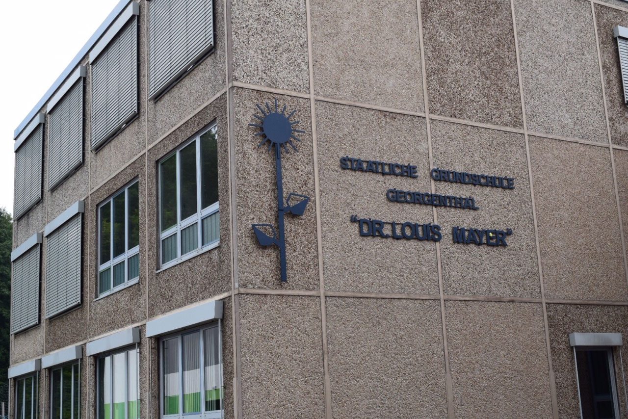 Das Schulgebäude mit dem Schriftzug Staatliche Grundschule Dr. Louis Mayer